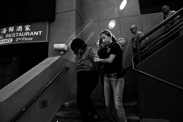 Law enforcement officers escort Dr. Hsiu-Ying "Lisa" Tseng out of her Rowland Heights clinic in March 2012 (Liz O. Baylen / Los Angeles Times)